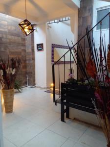 un couloir avec un escalier et un banc dans une chambre dans l'établissement Hotel Tao, à Atlixco