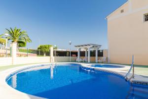 een groot zwembad met blauw water voor een gebouw bij Espanatour AGUAMARINA in Torrevieja