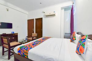 FabHotel Gitanjali في جايبور: غرفة نوم بسرير ومكتب وكرسي