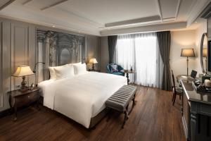 a bedroom with a large white bed and a window at Meritel Hanoi in Hanoi