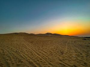 eine Wüste mit Sonnenuntergang in der Ferne in der Unterkunft Sakkara Country Club in Giza