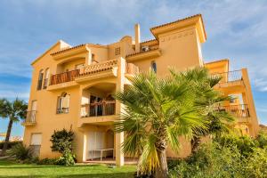 a building with a palm tree in front of it at Riviera Relax & Pool in Mijas Costa