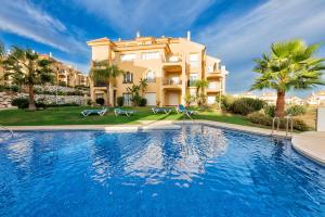 a villa with a swimming pool in front of a house at Riviera Relax & Pool in Mijas Costa