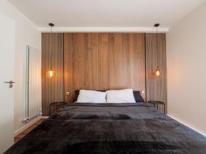 a bedroom with a large bed with wooden walls at Pass the Keys - Modern and spacious flat in South Central London in London
