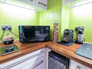 a kitchen with green tiled walls and a counter top at Pass the Keys - Modern and spacious flat in South Central London in London