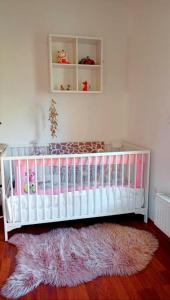 una nursery con una culla bianca e un tappeto rosa di Top Apartment in Langenhagen ad Hannover