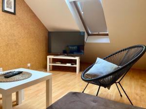 a living room with a chair and a table at Dekoratoria Apartments in Krakow
