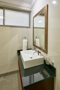 a bathroom with a sink and a mirror at Regent Select Hotel in Gaborone