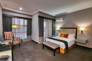 una stanza d'albergo con un letto e una sedia di Regent Select Hotel a Gaborone