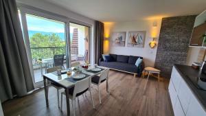 a living room with a table and a blue couch at Vila Primorka Apartmani Oleander in Šilo