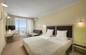 a hotel room with a large bed and a desk at Hotel Gergana - Ultra All Inclusive in Albena