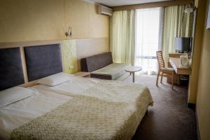 a hotel room with a bed and a chair at Hotel Gergana - Ultra All Inclusive in Albena
