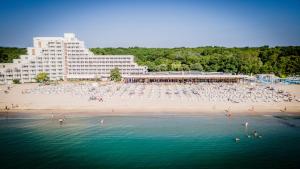 a beach with a large building and people in the water at Hotel Gergana - Ultra All Inclusive in Albena