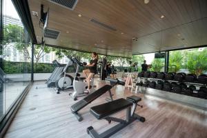 a gym with treadmills and a woman on a treadmill at Maitria Hotel Sukhumvit 18 Bangkok – A Chatrium Collection in Bangkok
