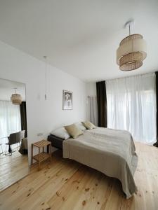 een witte slaapkamer met een bed en een tafel bij powiew in Świnoujście