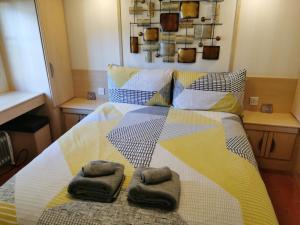 um quarto com uma cama com duas toalhas em Lovely Static Holiday Caravan near Whithorn em Whithorn