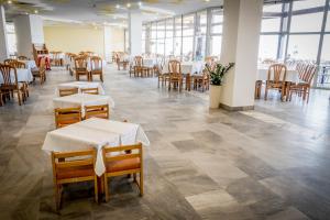 a dining room with tables and chairs and windows at Hotel Gergana - Ultra All Inclusive in Albena