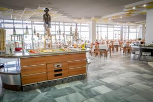 a restaurant with a bar with tables and chairs at Hotel Gergana - Ultra All Inclusive in Albena