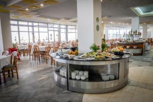 a buffet in a restaurant with tables and chairs at Hotel Gergana - Ultra All Inclusive in Albena