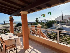 a balcony with a table and a view of a street at Villa Magda. in Agios Georgios Pagon