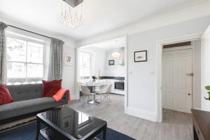 ein Wohnzimmer mit einem Sofa und einem Tisch in der Unterkunft PenthouseStays Notting Hill - Chic 2 Bedroom Apartment w/ King Beds - near Portobello Road & Kensington High Street in London
