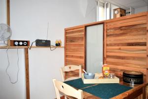 een eetkamer met een tafel en stoelen en een muur bij Studio sympa avec petit déjeuner entre canal et Loire in Roanne