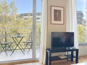 a living room with a tv and a balcony at Stay U-nique Apartments Venecuela in Barcelona