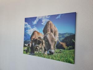 a picture of three cows grazing in a field at Ferienwohnung am See mit Bergblick & Sonnenbalkon in Blaichach