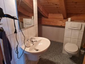 a bathroom with a white sink and a toilet at Ferienwohnung am See mit Bergblick & Sonnenbalkon in Blaichach