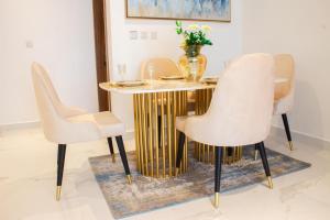 jadalnia ze złotym stołem i krzesłami w obiekcie Blue Bee 2 Bedroom Apartment w mieście Lagos
