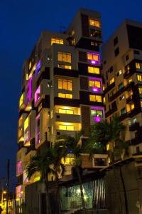 wysoki budynek z fioletowymi i różowymi światłami w obiekcie Blue Bee 2 Bedroom Apartment w mieście Lagos