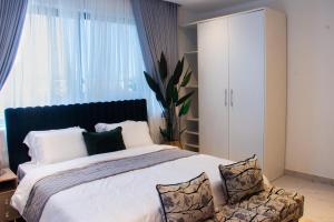 sypialnia z dużym łóżkiem i dużym oknem w obiekcie Blue Bee 2 Bedroom Apartment w mieście Lagos