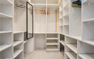 a walk in closet with white shelves and a mirror at Amazing Apartment In Cannes With Wifi in Cannes