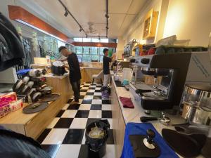 two people standing in a kitchen with a checkered floor at 75 MOTEL in Ha Giang +18 photos