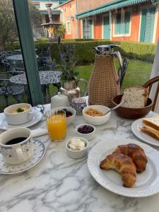 a table topped with plates of breakfast food and coffee at Hotel Draghi in San Antonio de Areco