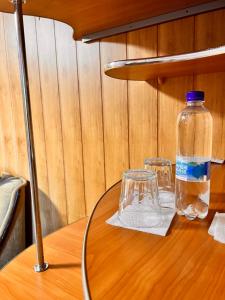 butelka wody i dwa kieliszki na stole w obiekcie Pid Yavorom w Iwano-Frankiwsku