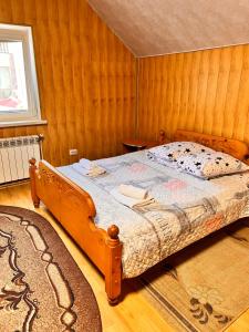 ein Schlafzimmer mit einem Holzbett in einem Zimmer in der Unterkunft Pid Yavorom in Iwano-Frankiwsk