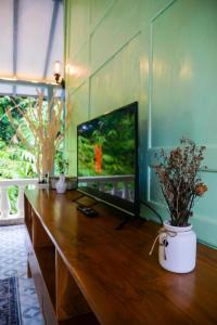 uma sala de estar com televisão numa mesa de madeira em Villa Kamar Tamu Selomartani 2 em Sleman
