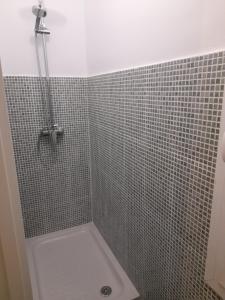 y baño con ducha y pared de azulejos. en Espoz habitaciones, en Madrid
