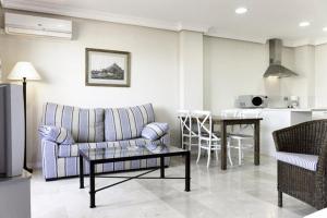 una sala de estar con un sofá y una mesa en Apartamentos Manilva Green, en Manilva