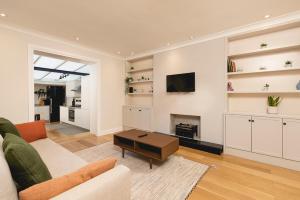 uma sala de estar com um sofá e uma lareira em PenthouseStays Chelsea - Luxury 2 Bedroom Apartment w/King Bed - near King's Road em Londres