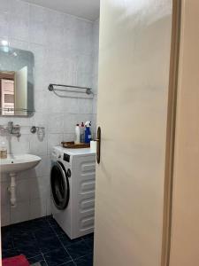 a bathroom with a washing machine and a sink at Gorica hill apartment in Podgorica