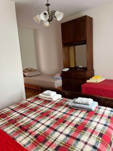a bedroom with two beds and a dresser and a red bed at Gorica hill apartment in Podgorica