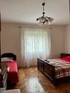 a bedroom with a bed and a ceiling fan and a window at Gorica hill apartment in Podgorica