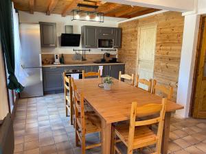 Il comprend une cuisine et une salle à manger avec une table et des chaises en bois. dans l'établissement Résidence - Gite La Mourée, à Vars