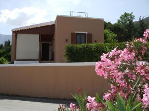 una casa con flores rosas delante de ella en Amari Krini House en Amárion