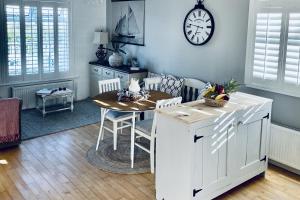 a kitchen with a table and a clock on the wall at Wavecrest Holiday Cottage in Garryvoe
