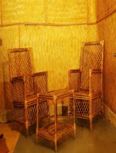 2 chaises, une table en bois, une table et 2 chaises dans l'établissement JUNGLE PARADISE FARM & GUEST HOUSE, à Masinagudi
