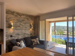 uma sala de estar com um sofá e uma mesa em Appart. vue mer avec piscine - Golfe de St Tropez em Les Issambres