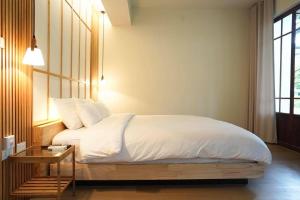 a bedroom with a bed with a wooden headboard and a table at Villa Panalai in Nakhon Nayok